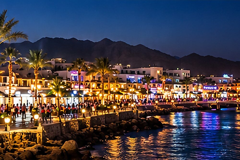 Nocna panorama promenady Naama Bay z restauracjami przy zatoce
