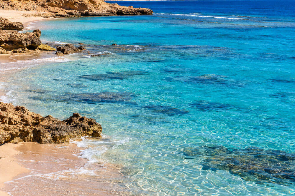 Naturalny fragment plaży z jasnym piaskiem na południu Marsa Alam